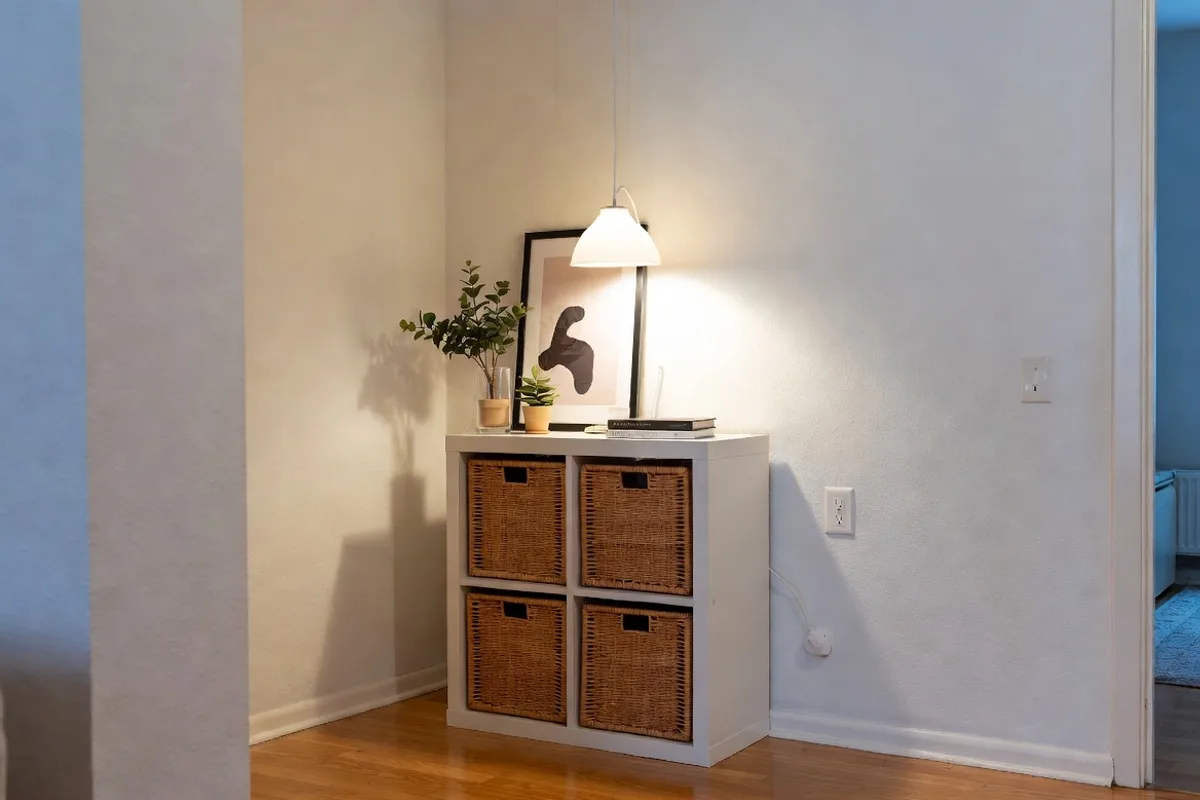 IKEA KALLAX shelf hack with rattan baskets and warm pendant lamp in a small budget living room