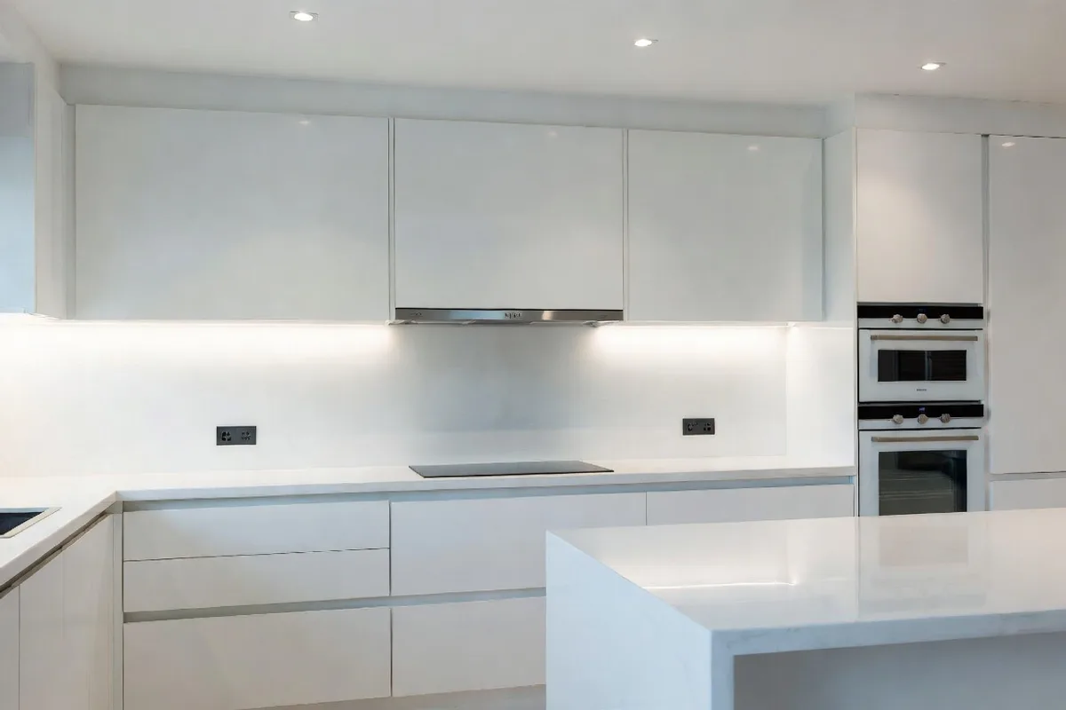 Modern kitchen with seamless large format white porcelain slab backsplash and high-gloss cabinets
