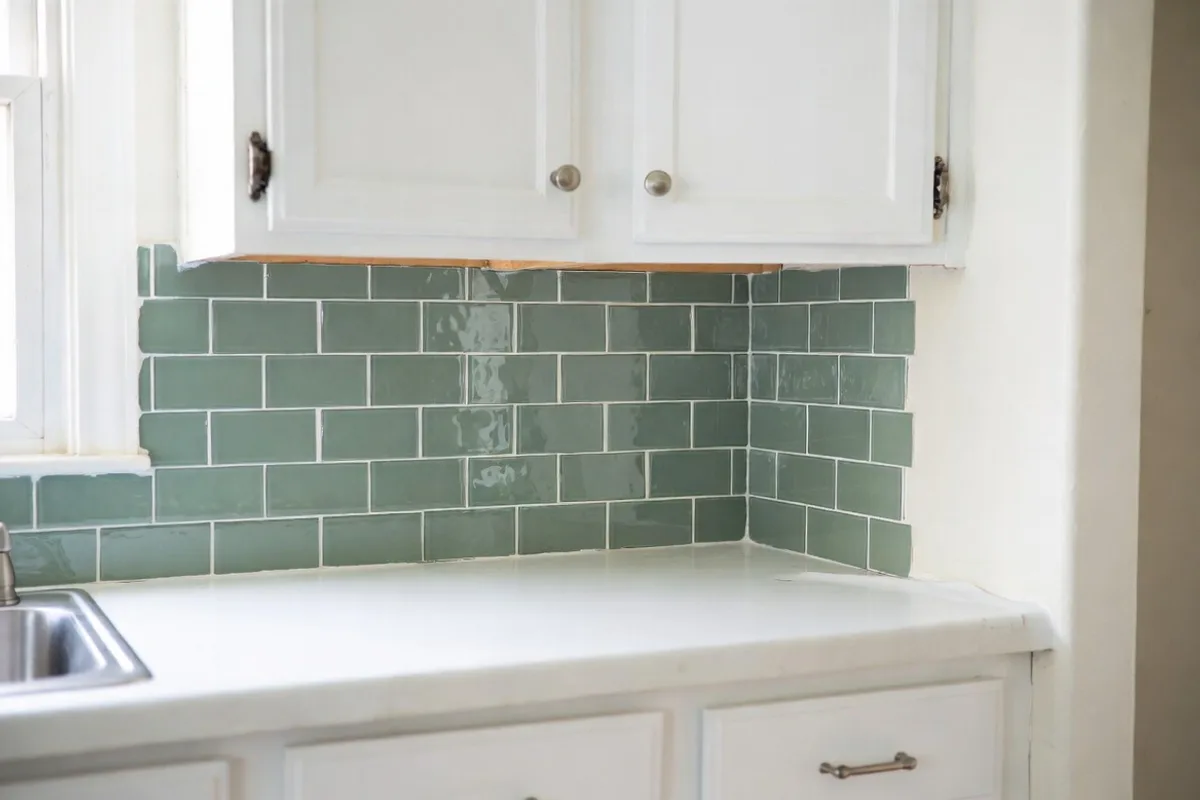 Affordable peel-and-stick sage green backsplash tiles in white kitchen